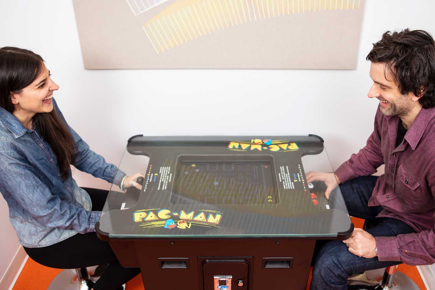 Two colleagues playing PacMan and laughing together.